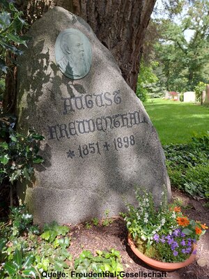 Bild vergr&ouml;&szlig;ern: August Freudenthals Grab auf dem Riensberger Friedhof wird bis heute vom Bremer Senat gepflegt. Der gro&szlig;e Naturstein vor einem m&auml;chtigen Baum passt gut zum Werk des Schriftstellers.
